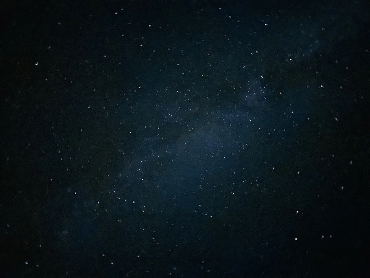 Wide field of stars with a soft blue-green Milky Way haze