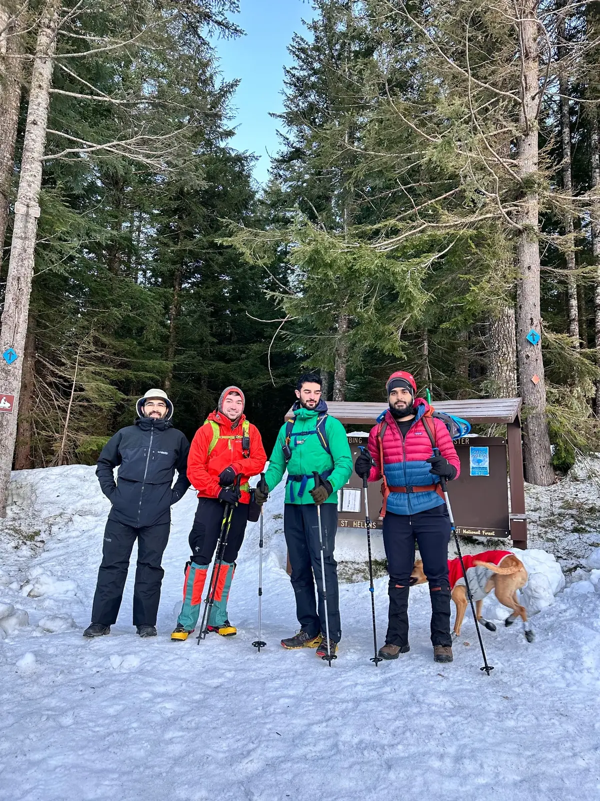 Four climbers standing together at a snowy Mount St. Helens trailhead