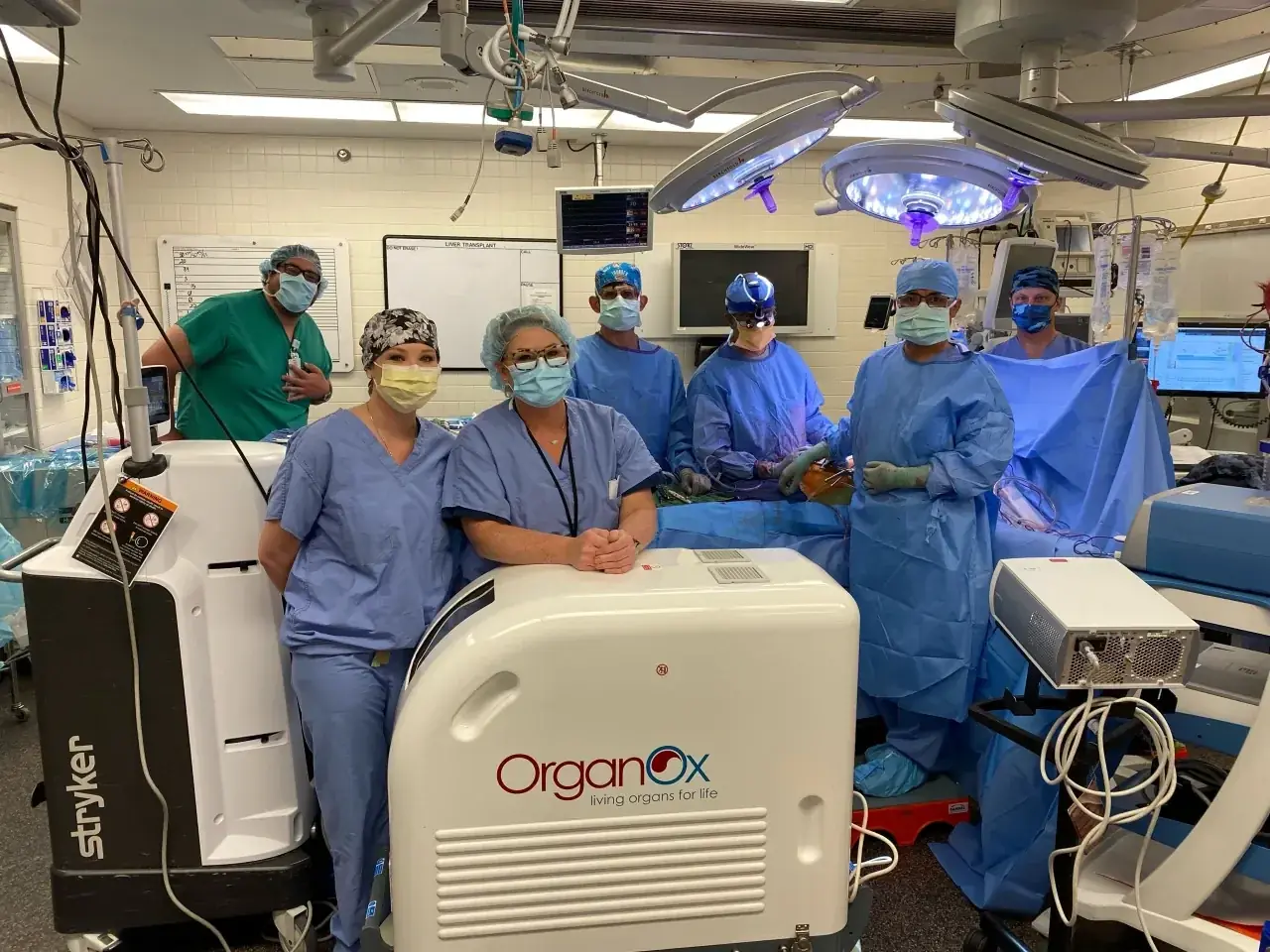 Transplant operating room team standing around an OrganOx metra liver perfusion system