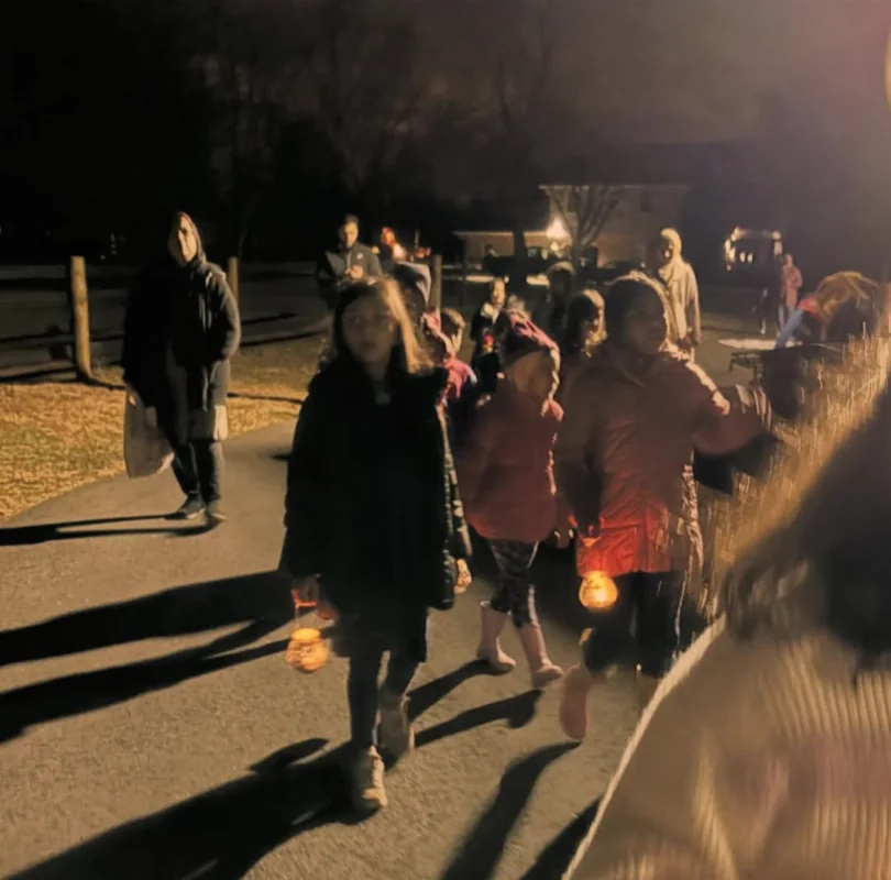 Children carrying lanterns during a night walk after an astronomy lesson
