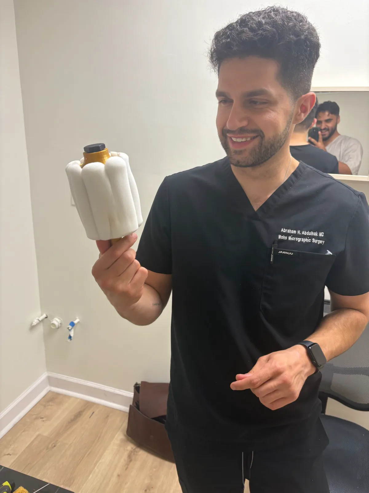 Waleed and a physician standing beside a prototype and design materials