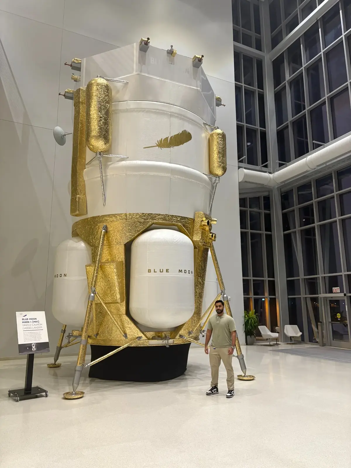 Waleed standing beside a full-scale Blue Moon lunar lander display